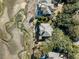 An aerial view of a home, nestled among the trees, surrounded by marshland at 1136 Ocean Forest Ln, Seabrook Island, SC 29455
