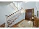 Bright foyer featuring a wooden door, hardwood floors, and a staircase illuminated by a round window at 1136 Ocean Forest Ln, Seabrook Island, SC 29455