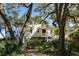 Charming home with mature trees providing shade and privacy, complemented by a welcoming entryway and staircase at 1136 Ocean Forest Ln, Seabrook Island, SC 29455