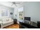 A well lit office space with hard wood floors, two windows and a cozy white sofa at 1136 Ocean Forest Ln, Seabrook Island, SC 29455