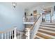 Bright foyer with hardwood stairs, white railings, and a glimpse of the open-concept living area at 1136 Ocean Forest Ln, Seabrook Island, SC 29455