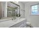 Bright bathroom featuring a white vanity with quartz countertop and framed mirror reflecting a tiled glass enclosed shower at 117 Swan Dr, Summerville, SC 29485