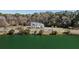 Breathtaking aerial view of a white farmhouse style home overlooking a serene pond and lush greenery at 1174 Hitchfield Ln, Awendaw, SC 29429