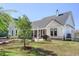 Spacious backyard showcasing the white farmhouse, screened porch, and lush green lawn at 1174 Hitchfield Ln, Awendaw, SC 29429