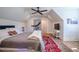 Bedroom with a bed, ceiling fan, television, dresser and red and white patterned rug over wood floor at 1174 Hitchfield Ln, Awendaw, SC 29429