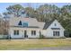 Charming white farmhouse with a covered front porch, black window trim, and an American flag at 1174 Hitchfield Ln, Awendaw, SC 29429