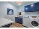 Well-organized laundry room with blue cabinets, a white countertop, a stainless steel washer and dryer, and art at 1174 Hitchfield Ln, Awendaw, SC 29429
