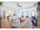 Open-concept living room featuring white sofas, hardwood floors, and seamless access to the kitchen at 1174 Hitchfield Ln, Awendaw, SC 29429
