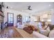 Bright living room with white sofas, wood floors, and an open layout leading to the kitchen at 1174 Hitchfield Ln, Awendaw, SC 29429