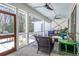 Inviting screened porch with comfortable wicker furniture and a light blue ceiling at 1174 Hitchfield Ln, Awendaw, SC 29429