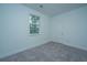 Empty bedroom with neutral carpet and light walls, showcasing a window and a closet door at 1303 Twin Rivers Dr, Wando, SC 29492