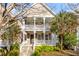 Charming two-story home with a welcoming front porch and upper level balcony, enhanced by mature trees and lush greenery at 1331 Appling Dr, Mount Pleasant, SC 29464