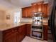 Warm kitchen featuring granite countertops, stainless steel appliances, and custom wood cabinets at 1344 Pickett St, Charleston, SC 29412