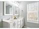Well-lit bathroom with double sinks, modern fixtures, and a large window providing natural light at 1458 Clarendon Way, Mount Pleasant, SC 29466