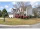 Charming two-story home with a manicured lawn, blooming bushes, and a two-car garage at 1458 Clarendon Way, Mount Pleasant, SC 29466