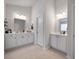 Bright bathroom featuring dual vanities with white cabinets and modern fixtures under contemporary lighting at 146 Brant Dr, Summerville, SC 29483