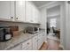 Convenient butler's pantry with granite countertops, white cabinets and access to an office at 146 Brant Dr, Summerville, SC 29483