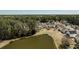 Gorgeous aerial view overlooking a pond surrounded by trees and well-maintained homes in a desirable community at 1465 Water Edge Dr, Charleston, SC 29492