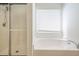 Bright bathroom featuring soaking tub, glass-enclosed shower, and a large window at 1465 Water Edge Dr, Charleston, SC 29492