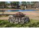 The backyard features a charming stone fire pit and lush green surroundings perfect for outdoor entertaining at 1465 Water Edge Dr, Charleston, SC 29492