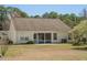The rear of the home features a screened-in porch, large windows, and a manicured lawn with mature trees at 1465 Water Edge Dr, Charleston, SC 29492