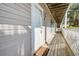 Hallway with a white door and brown door mat on a deck showcasing outdoor lights, outdoor furniture, and palm trees at 1530 Fort Johnson Rd # 3C, Charleston, SC 29412