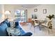 Cozy living room features a comfortable blue sofa, a dining table, and sliding glass doors leading to a patio at 1530 Fort Johnson Rd # 3C, Charleston, SC 29412