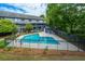 Aerial view of a community pool, nestled amongst trees, next to a blue apartment complex at 1530 Fort Johnson Rd # 3C, Charleston, SC 29412