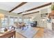 Bright living room with exposed beams, brick fireplace, and comfortable seating overlooking outdoor space at 1540 Strathmore Ln, Mount Pleasant, SC 29464