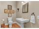 Elegant powder room featuring hardwood floors, a pedestal sink, and decorative accents at 1540 Strathmore Ln, Mount Pleasant, SC 29464