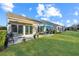 Beautiful backyard with a lush green lawn, a cozy patio, and outdoor furniture under a bright blue umbrella at 157 Sea Lavender Ln, Summerville, SC 29486