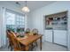 Dining area with wooden table set for four, a window, and a laundry closet featuring modern appliances at 157 Sea Lavender Ln, Summerville, SC 29486
