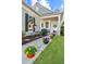 Beautiful front exterior showcasing landscaped yard and covered porch adorned with colorful potted flowers at 157 Sea Lavender Ln, Summerville, SC 29486