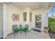 Charming front porch featuring a seating area, decorative wall art, and a festive wreath on the front door at 157 Sea Lavender Ln, Summerville, SC 29486