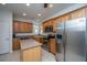 Open kitchen with stainless steel refrigerator, wood cabinets, countertop island, and tile flooring at 157 Sea Lavender Ln, Summerville, SC 29486