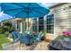 Charming patio with a blue umbrella, comfortable seating, potted plants, and an inviting outdoor space for relaxation at 157 Sea Lavender Ln, Summerville, SC 29486
