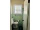 Small bathroom with mint-green tile and a window offering light in a compact space at 1610 Larry St, North Charleston, SC 29406