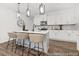 Stylish kitchen with white cabinets, stainless steel appliances, a center island with bar seating, and contemporary pendant lighting at 169 Surf Bird St # 514P, Summerville, SC 29486