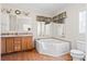 Bathroom with a soaking tub, double vanity sink, and light wood cabinetry at 1816 Grimball Rd, Charleston, SC 29412