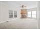 Bright living room with a stone fireplace, neutral walls, and large windows for natural lighting at 1816 Grimball Rd, Charleston, SC 29412