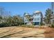 Beautifully landscaped exterior featuring blue siding, white trim, a double garage, and lush green lawn at 1899 N James Gregarie Rd, Mount Pleasant, SC 29466