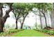 Gathering walking down beautifully landscaped green space, framed by mature trees, offering a picturesque outdoor experience at 1039 Swamp Rose Run, Summerville, SC 29485