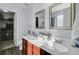 Well-lit bathroom with double sinks, dark cabinets, and a walk-in closet at 200 Short Woods Ct, Summerville, SC 29486