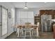 Bright dining area with a table set for four, a large window, and convenient access to the kitchen at 200 Short Woods Ct, Summerville, SC 29486