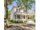 Charming two-story home with a landscaped yard, covered porch, and a bright blue front door at 21 Limehouse St, Charleston, SC 29401