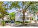 Beautiful two-story white home with a red roof, mature trees, and a paved driveway at 21 Limehouse St, Charleston, SC 29401