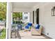 Inviting front porch with comfortable seating, a decorative rug, and classic white columns at 21 Limehouse St, Charleston, SC 29401