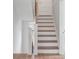 Elegant staircase with wood treads and white risers, complemented by a light wood handrail and light walls at 21 Limehouse St, Charleston, SC 29401