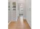 Spacious walk-in closet with custom storage cabinets, drawers, wood floor, and bright lighting at 21 Limehouse St, Charleston, SC 29401