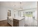 Bright kitchen with island, pendant lighting, stainless dishwasher and sink, and hardwood floors at 210 Quimby Hill Dr, Huger, SC 29450